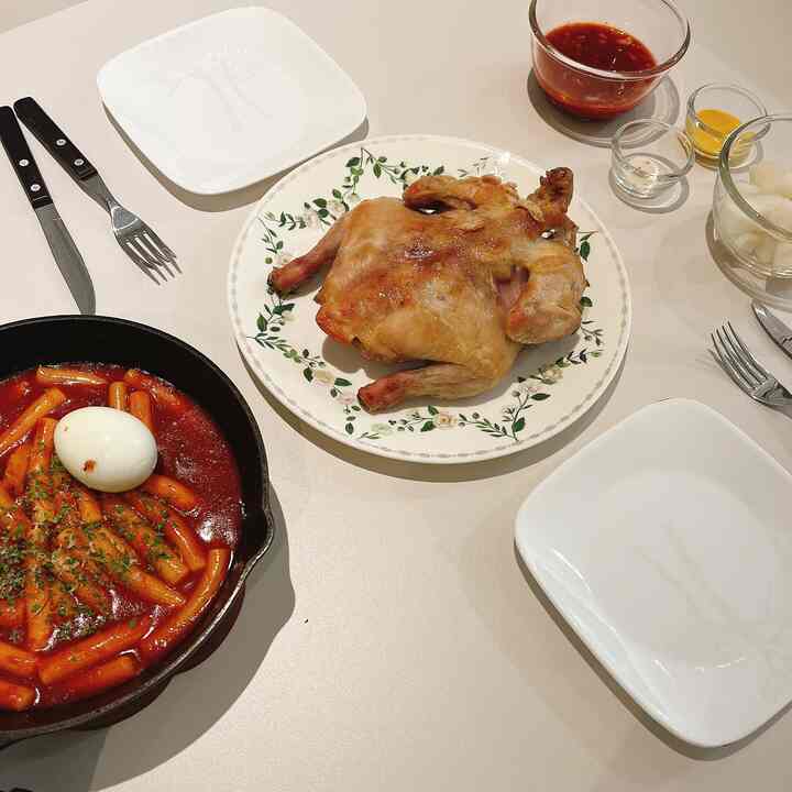 白いテーブルの上にミールキットの料理とカトラリーが並べられたシンプルな夕食の空間