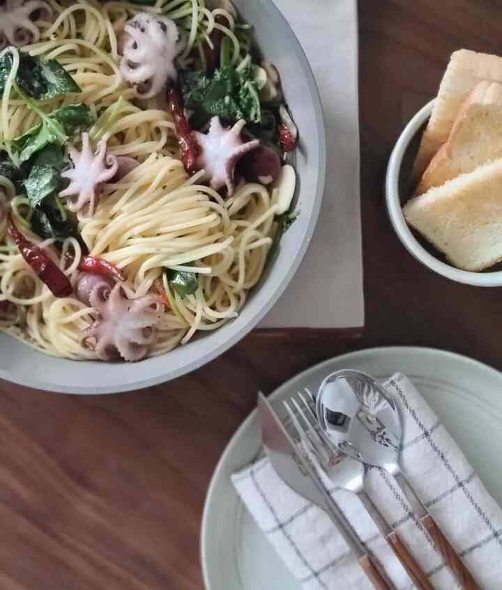 ブラウンの木目調ダイニングテーブルに白い皿とカトラリーが配置されたダイニング、パスタとパンの温かみあるブランチ空間