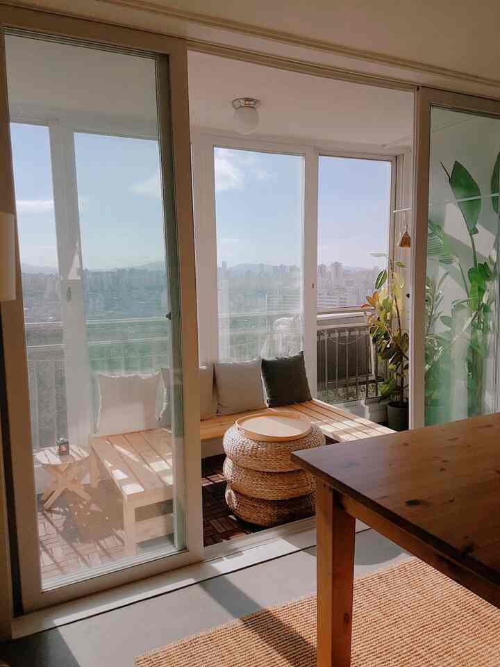 Warm wood tones and natural colors define a veranda home cafe flooded with bright autumn sunlight through glass doors