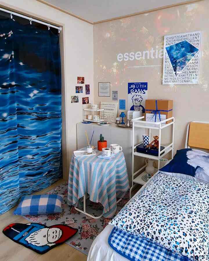 Blue-toned bedroom featuring bed, curtain, and rugs arranged harmoniously creating a cozy atmosphere