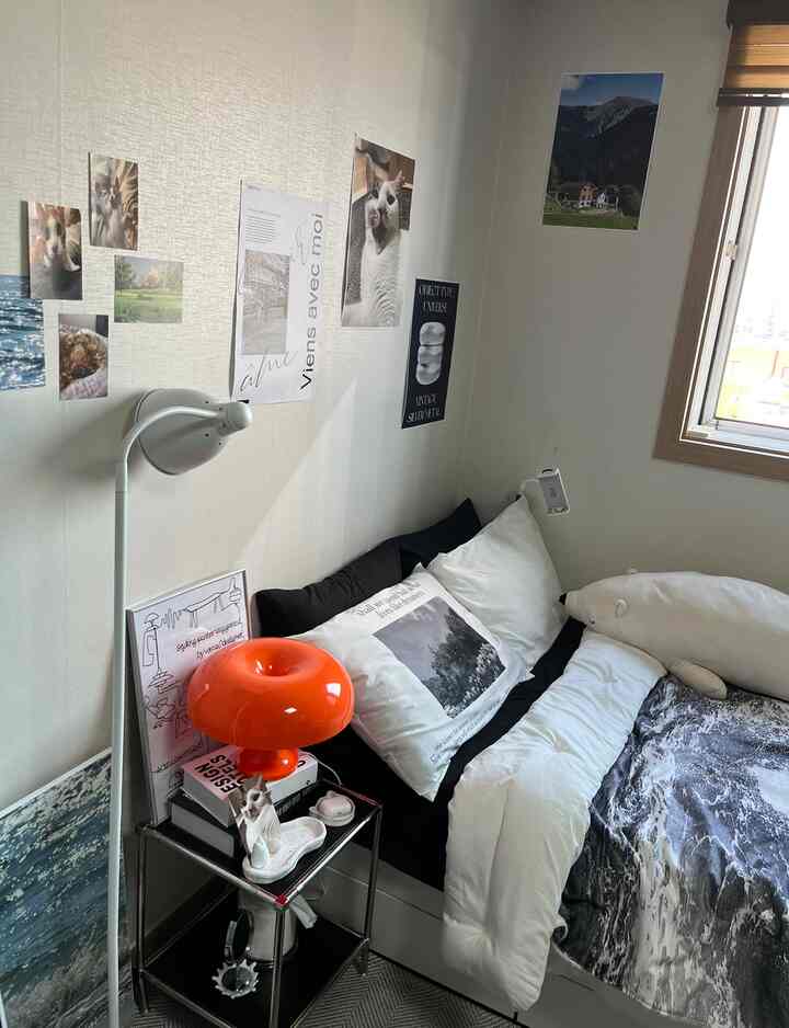 ホワイトとブラックを基調とした一人暮らしの寝室で、個人の小物と猫の写真が配置された雰囲気のある空間