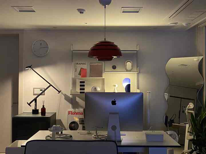 白と黒のトーンのモダンなホームオフィス、iMacと照明が配置された雰囲気のあるインテリア