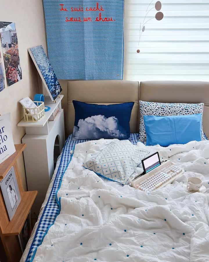 White and blue toned bedroom featuring patterned cushions and duvet cover creating a cozy atmosphere