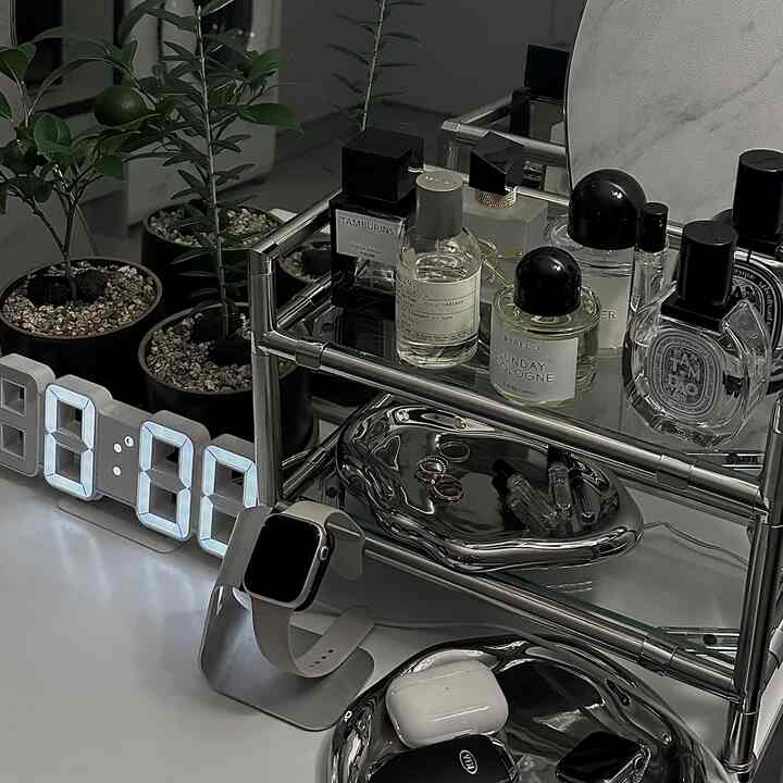 白と黒のトーンが調和するモダンな空間、金属製の棚に香水やアクセサリーが整然と配置された印象的なインテリア