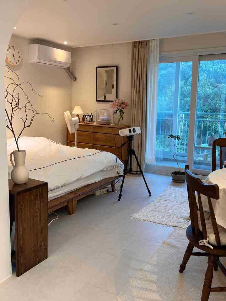 White and wood-toned bedroom featuring wooden furniture and a veranda with a minimalistic atmosphere