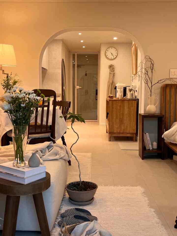Beige and natural wood-tone living and kitchen space for two-person household, featuring cozy home cafe setup and warm, natural decor