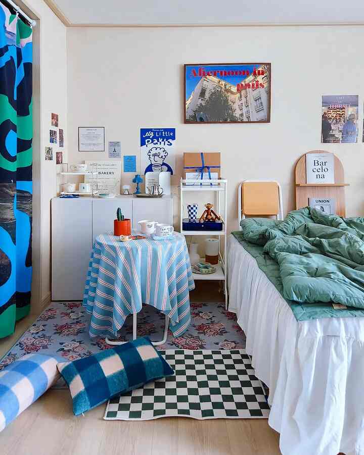 White-walled bedroom with blue-themed decor, featuring a bed and round table in a natural, cozy setting