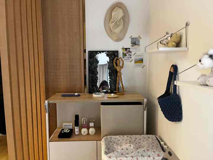 Natural wood tones and beige vanity space featuring vintage accessories and a forest mirror creating a cozy selfie zone