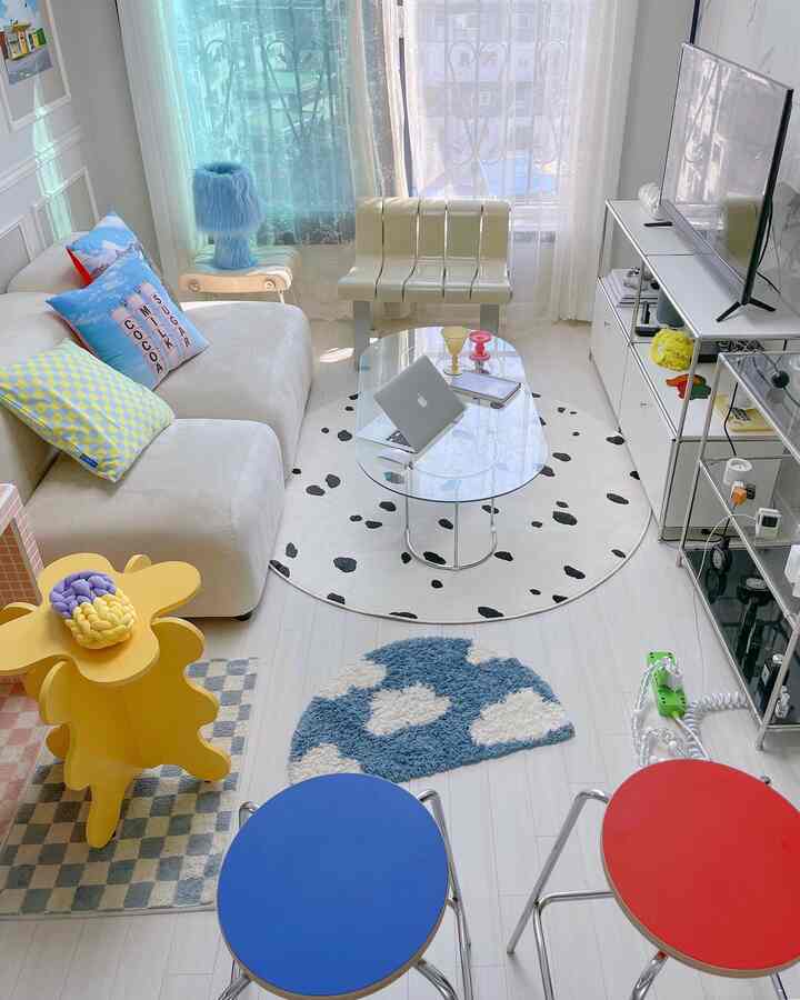Bright living room in white and blue tones, featuring a beige sofa and transparent coffee table with a minimalistic atmosphere