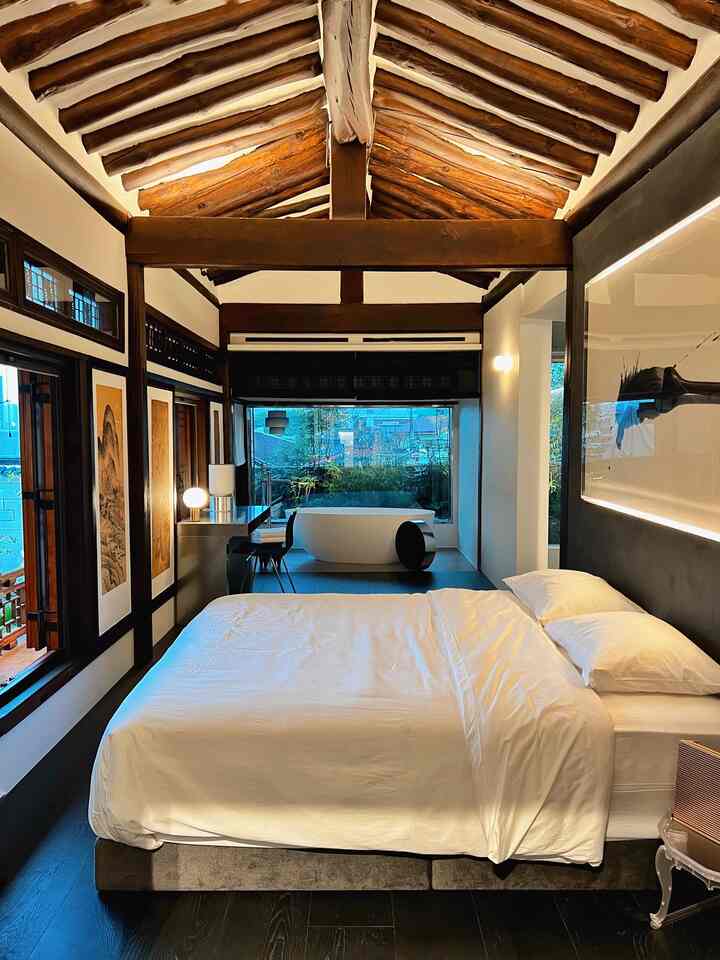 Wood tone and white Korean-style bedroom featuring traditional hanok beams with modern interior design elements