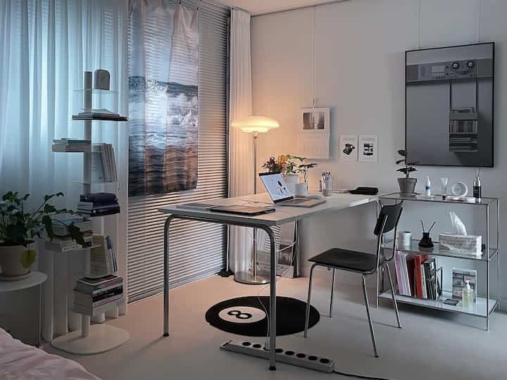 White and black toned home office featuring desk and chair with a clean and modern workspace atmosphere