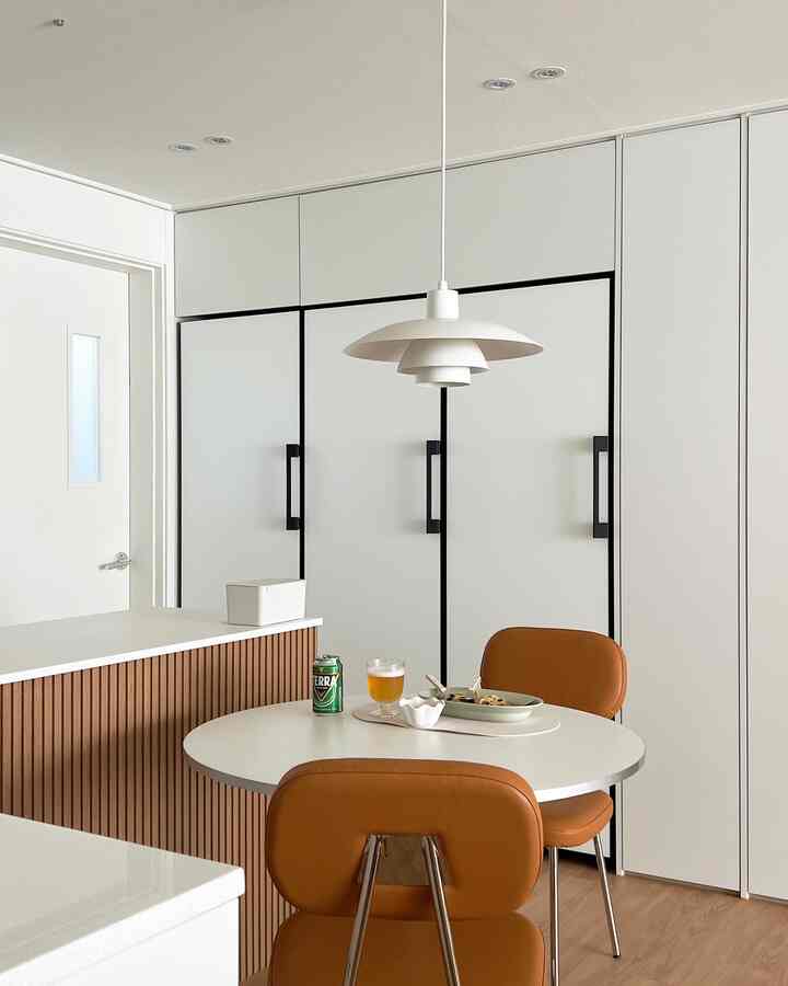 White and wood tone kitchen featuring caramel leather dining chairs creating a cozy atmosphere