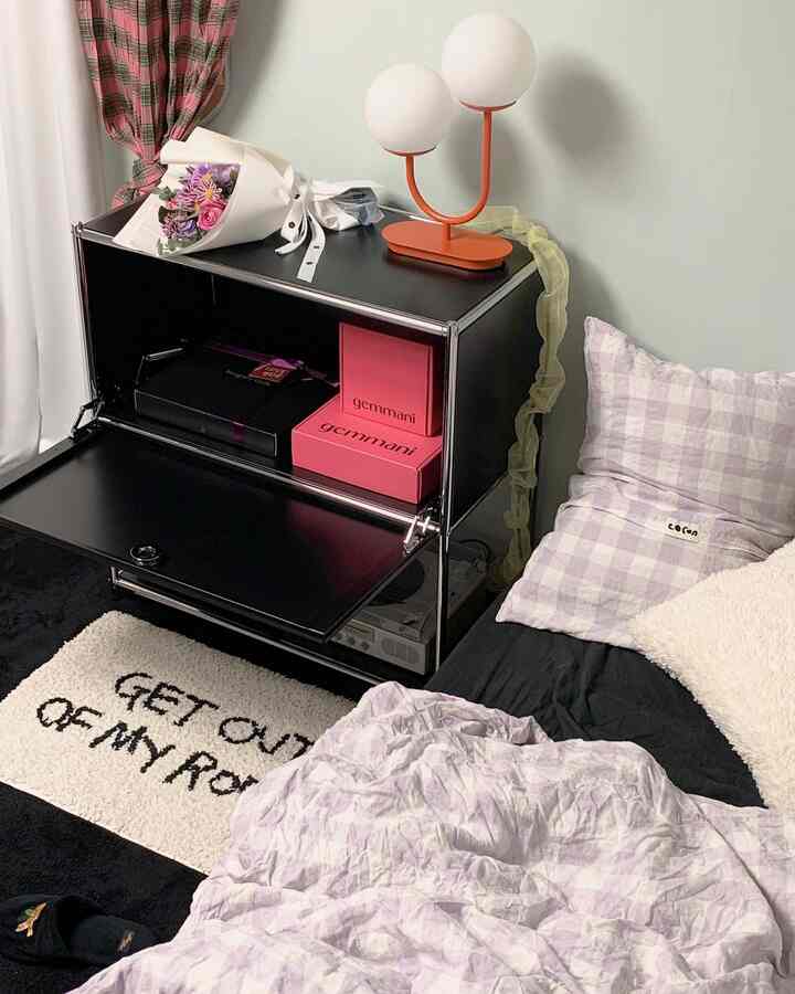 Black and beige toned bedroom featuring modular storage cabinet and cozy bedding
