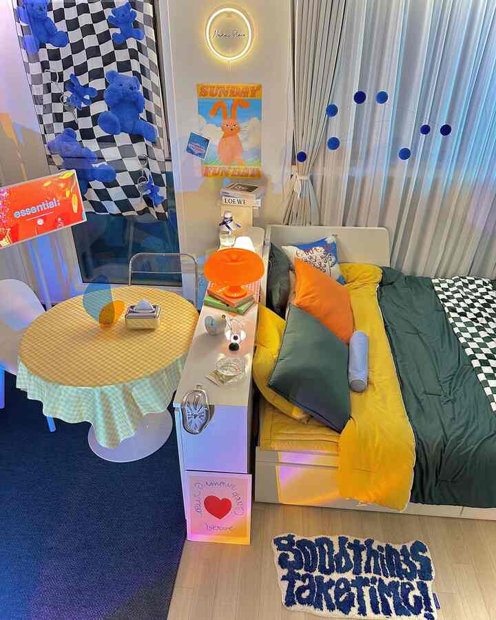 A studio living room in harmonious blue and yellow tones featuring a table lamp and sofa bed in mid-century modern style