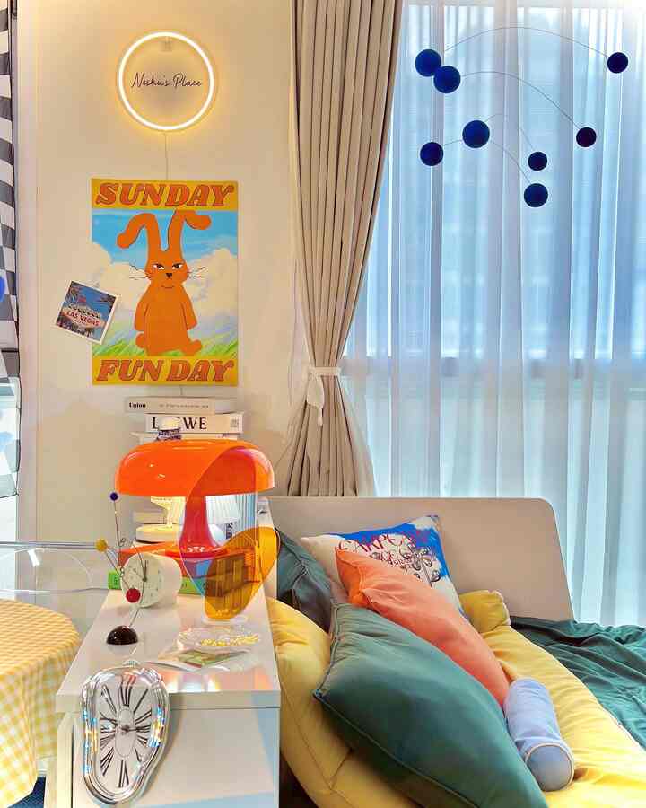 Mid-Century Modern studio apartment with warm beige curtains and vibrant orange lighting, featuring a sofa bed with colorful cushions creating a cozy atmosphere