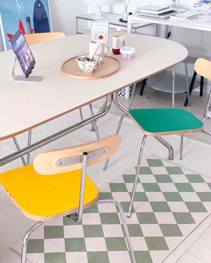 白とナチュラルカラーのリビングダイニング、黄色と緑の椅子が配置されたモダンなインテリア