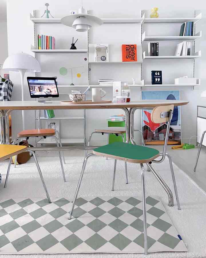 白を基調としたダイニングルーム、カラフルな椅子とテーブルランプが配置されたモダンなインテリア