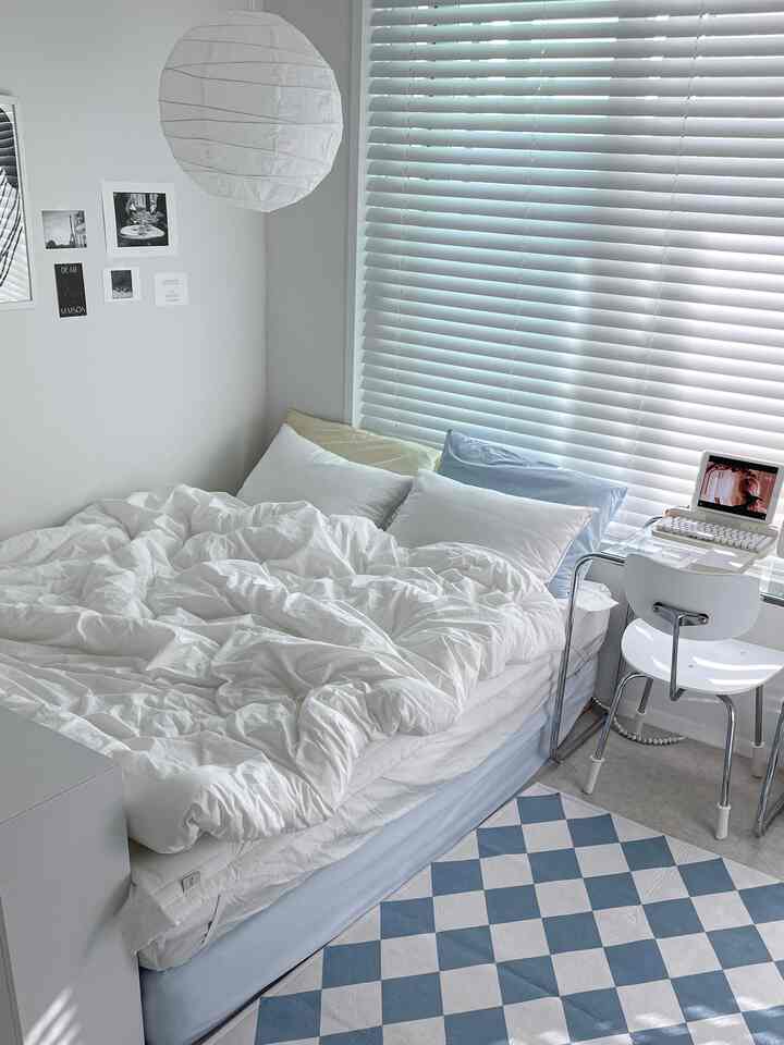 White-toned bedroom featuring a large bed, transparent desk, and neat blinds with a modern atmosphere