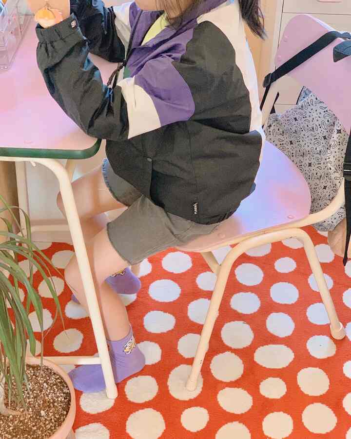 赤と白のドット柄カーペットが敷かれた空間にピンクのダイニングテーブルとチェアが置かれた子供部屋の印象的なインテリア