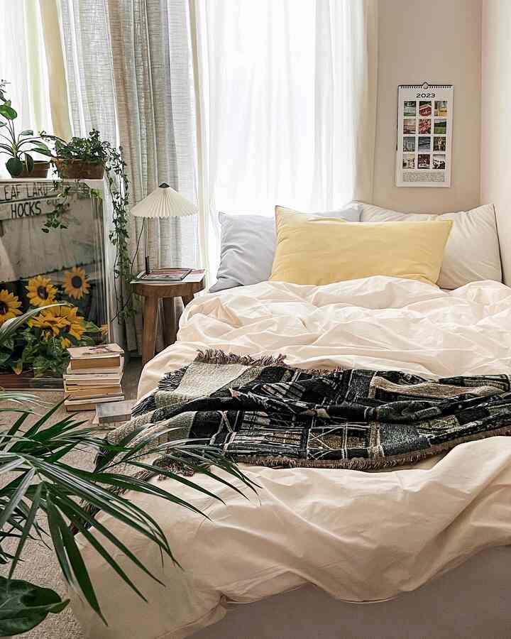Bright white and yellow toned bedroom with high-density duvet cover and striped pillows, creating a cozy atmosphere