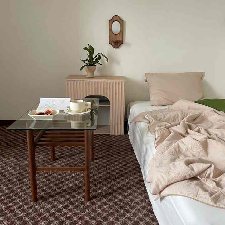 Beige and white toned bedroom featuring natural modern wooden coffee table and bedding creating a cozy atmosphere