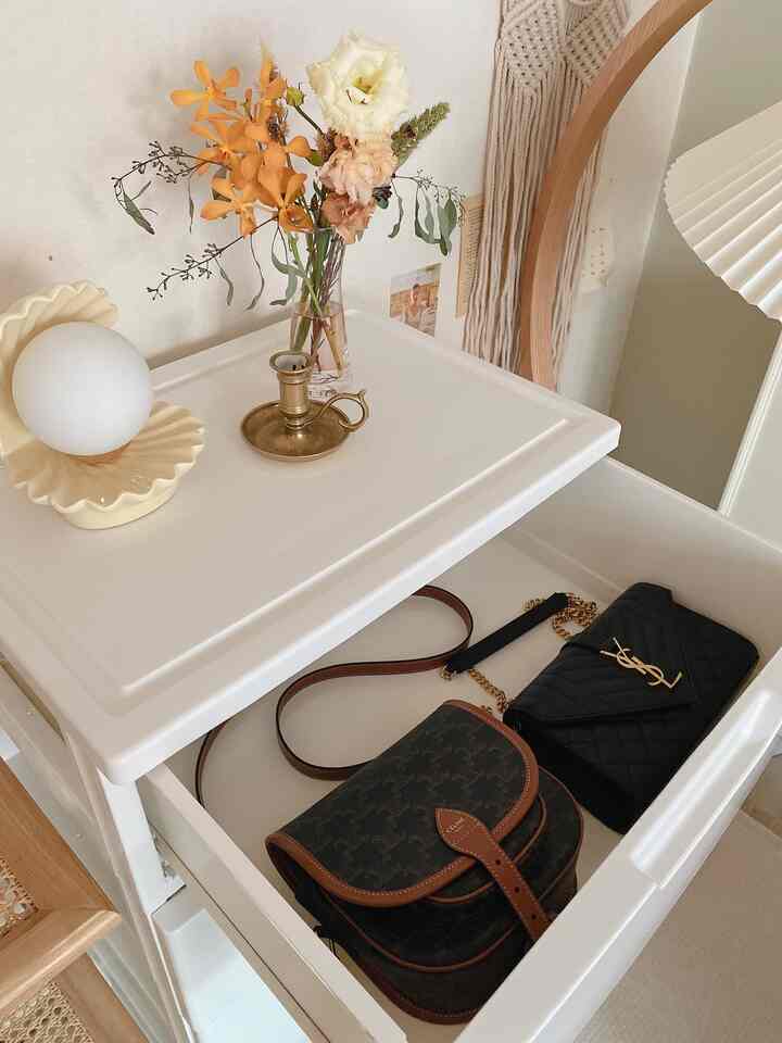 白と茶色のトーンの化粧台、ゴールドのキャンドルホルダーと花瓶が配置された落ち着いたスタイリッシュな空間