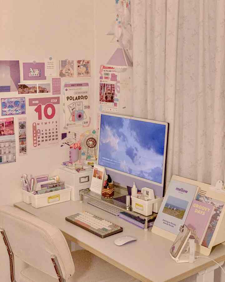 ホワイトとベージュの色調のホームオフィス空間、中央にアイマックと整頓された机、壁に多様なポスターが飾られた明るい作業部屋