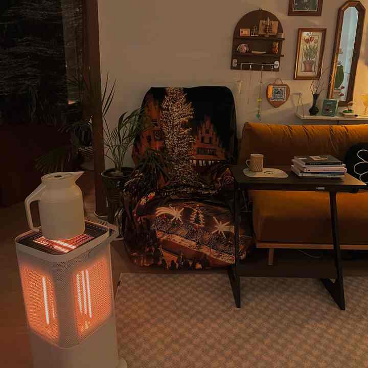 暖かいオレンジとブラウンの色調のリビング、一人掛けソファとヒーター、コーヒーテーブルが配置された雰囲気のある空間