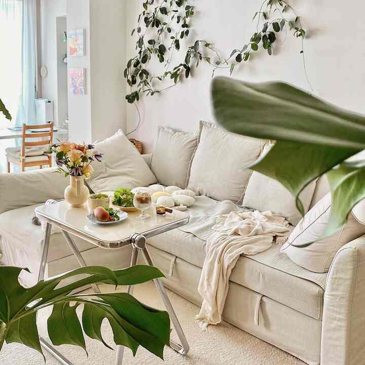 Beige and white toned living room featuring a natural modern sectional sofa and plants creating a cozy space