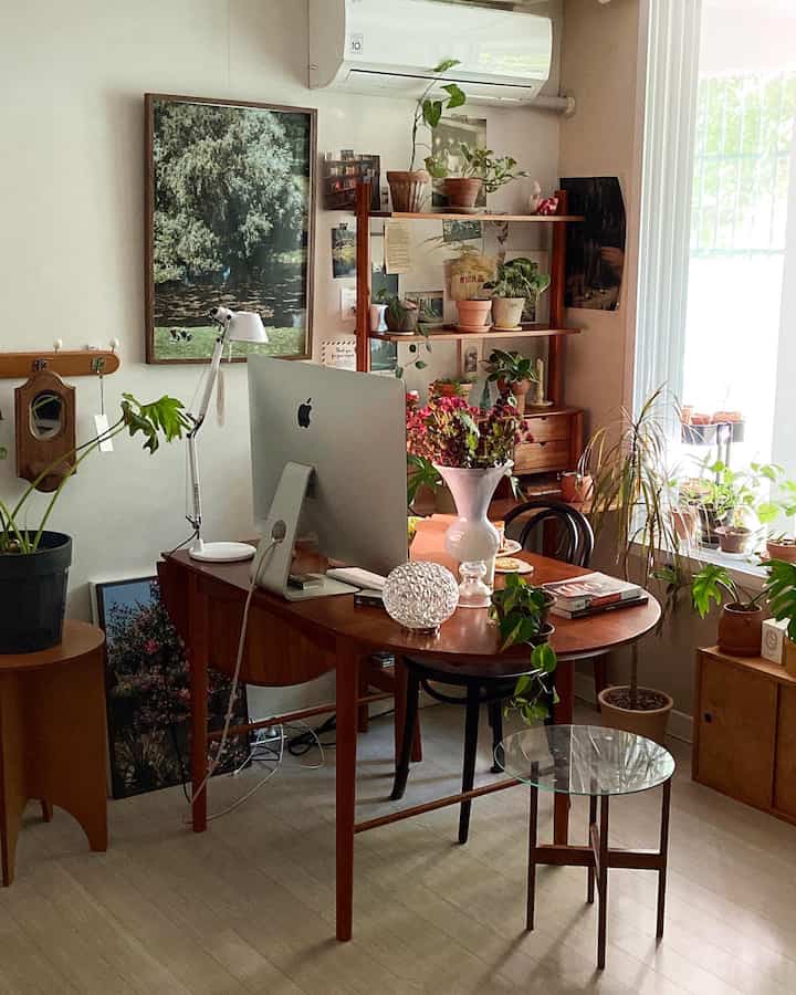 ウッドトーンと植物が調和するナチュラルモダンな寝室、木製デスクとiMacが配置された在宅勤務スペース