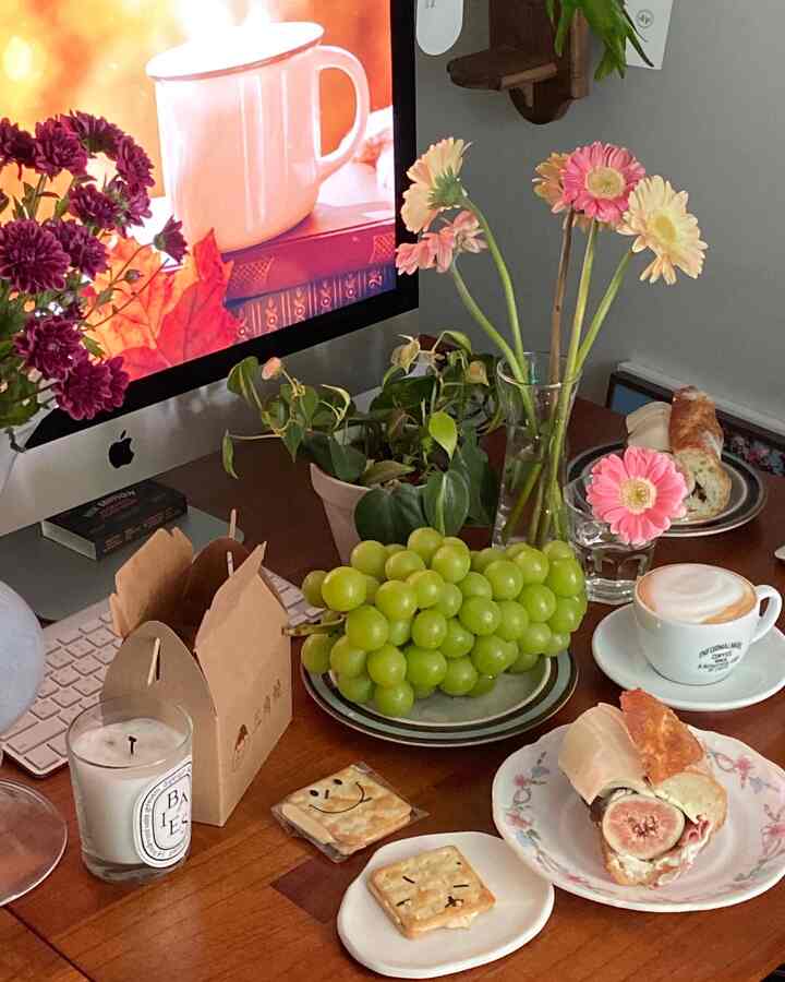 Cozy home office space with brown wooden table featuring computer and home cafe items