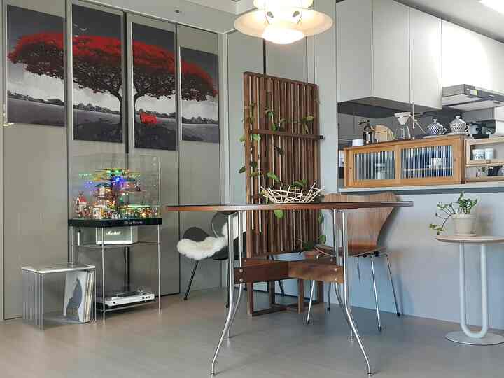 Modern dining room in white and wood tones featuring a pendant light and wall art, creating a refined atmosphere