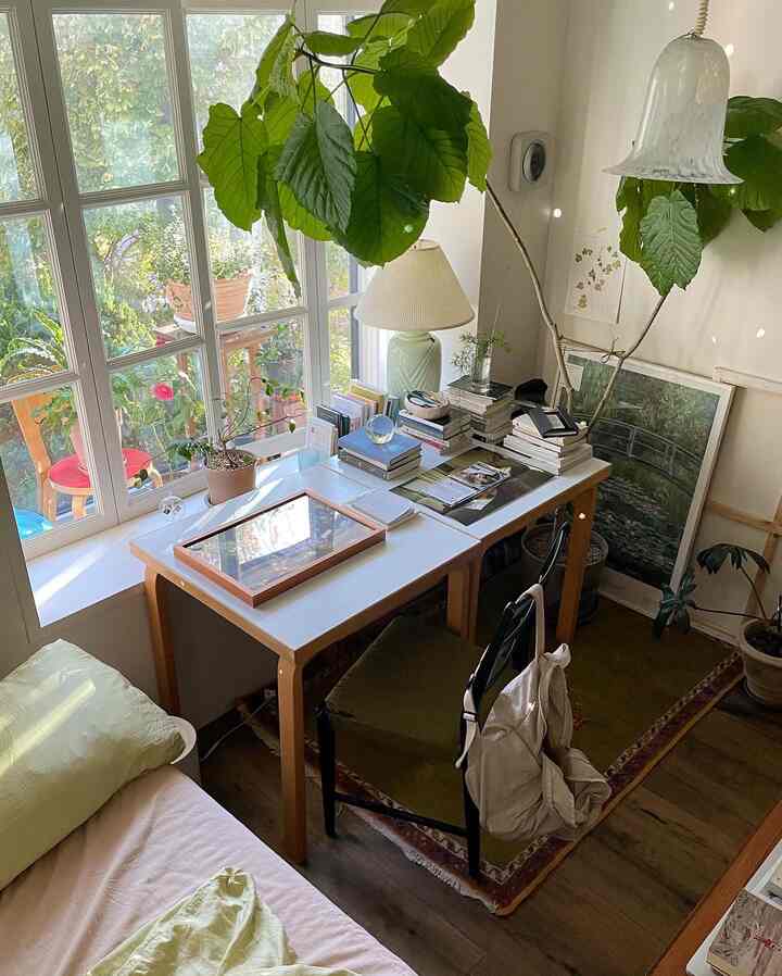 Natural-toned small room with a veranda view, featuring a wood table and plants creating a cozy workspace