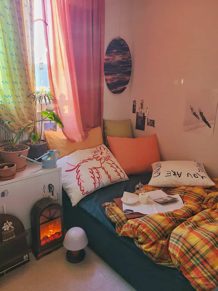 Warm autumn-toned bedroom featuring a cozy bed, curtains, and plants creating a natural, inviting atmosphere