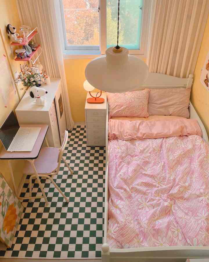 Pink and white themed bedroom featuring a single bed and desk arranged in a cozy small room interior