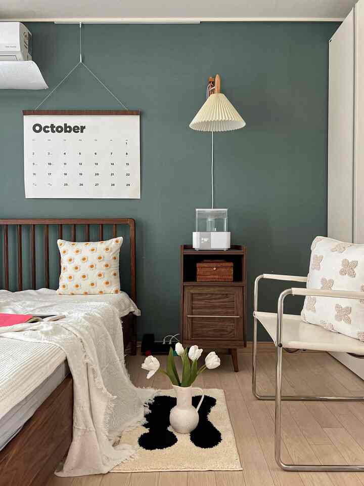 ウッドトーンとホワイトが調和した寝室、ナイトテーブルや寝具、花瓶が配置された雰囲気のあるインテリア