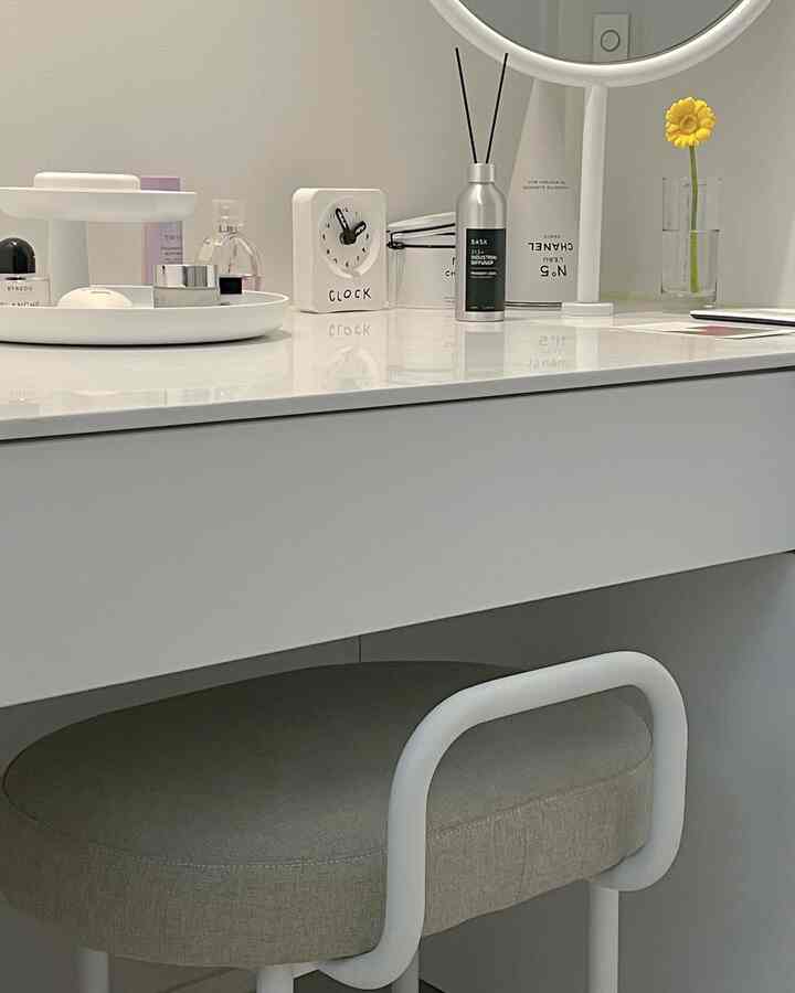 White and beige vanity space featuring a tidy diffuser and stool, creating a simple and clean atmosphere