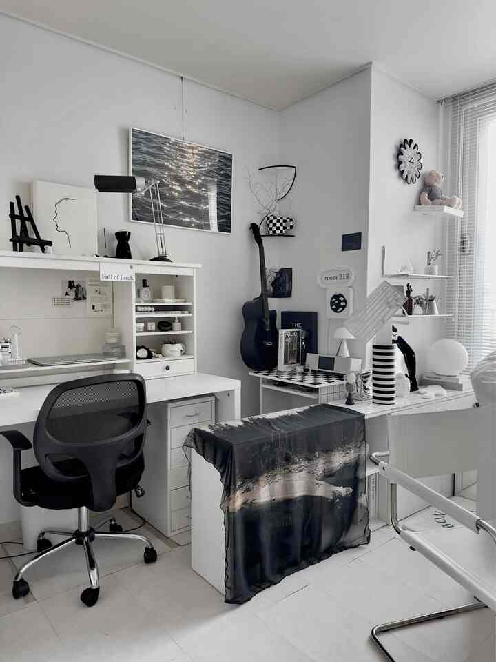 Monotone small home office in white and black, featuring a desk and office chair centered for a clean workspace