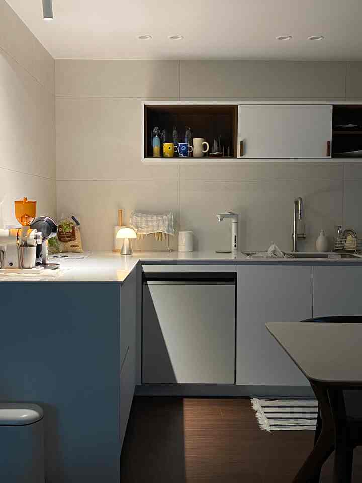 Modern kitchen with white cabinetry and wood tones featuring home cafe items creating a cozy atmosphere