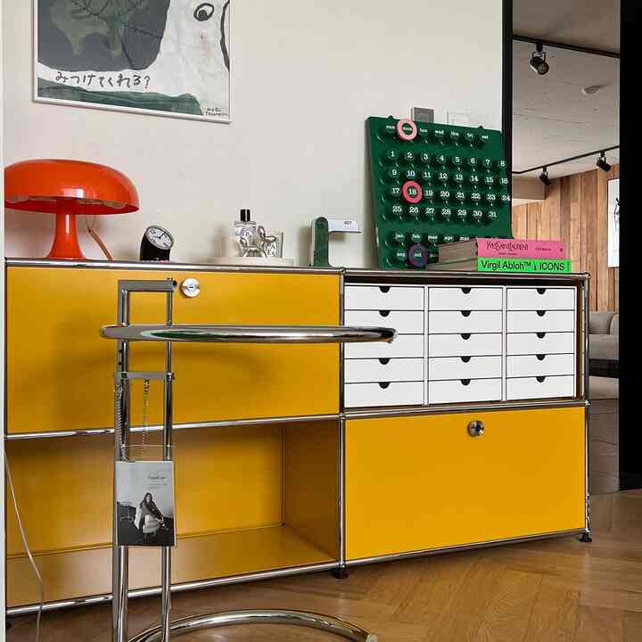 Modern space featuring a yellow and white modular storage unit with an orange table lamp