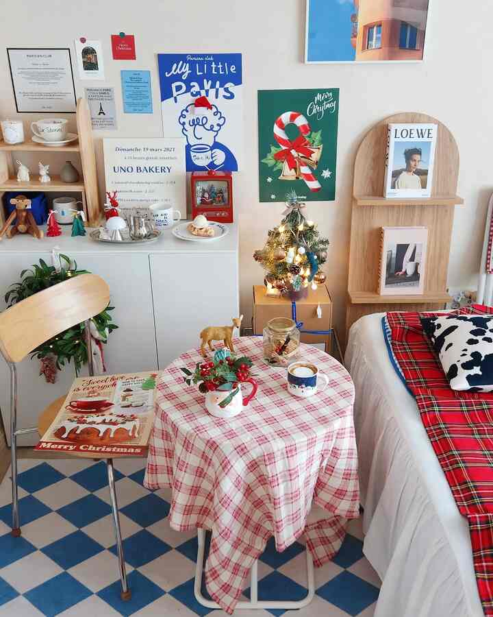 ホワイトとブルーの色調のリビング、クリスマス飾りとチェック柄のテーブルクロスが配置された温かみのあるインテリア