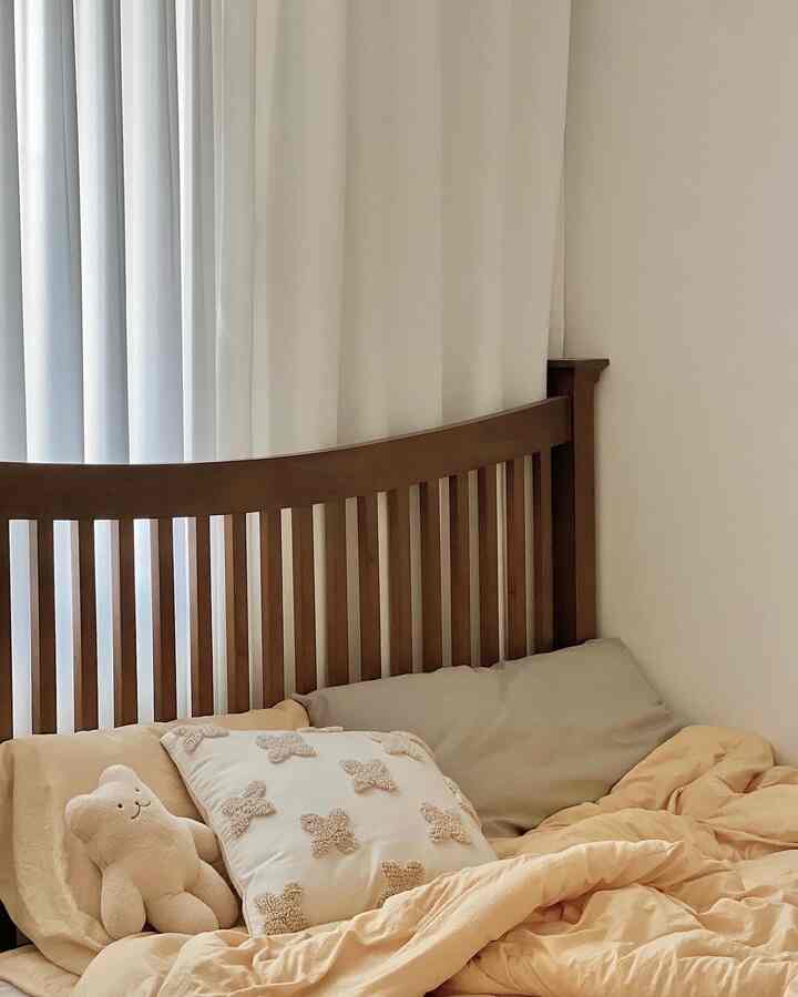 White and brown toned bedroom featuring wooden bed with beige bedding creating a cozy atmosphere