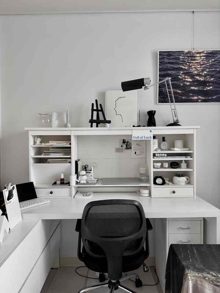 White and black toned home office space featuring a clean desk and office chair with a modern atmosphere