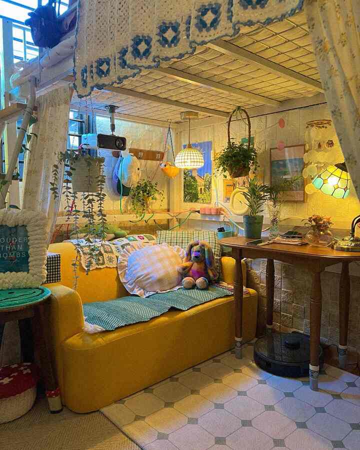 黄色のソファと二段ベッドがある居心地の良い寝室、植物とラグが配置された自然な雰囲気のインテリア