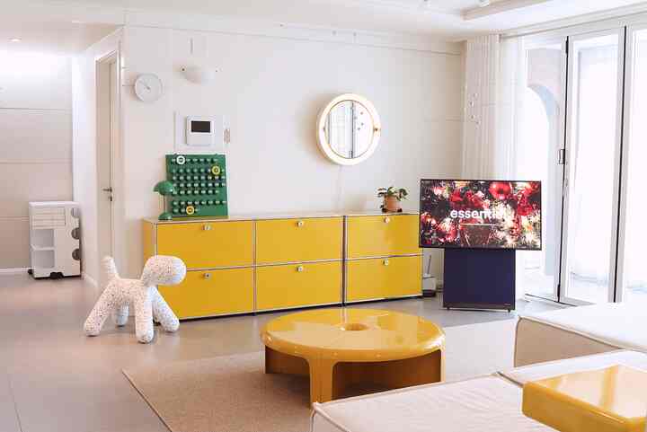 Modern living room with white background featuring yellow modular furniture and a round coffee table