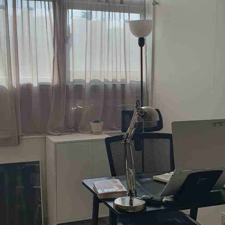 White and black toned 8-평 studio apartment workspace featuring desk and lamp with a clean atmosphere