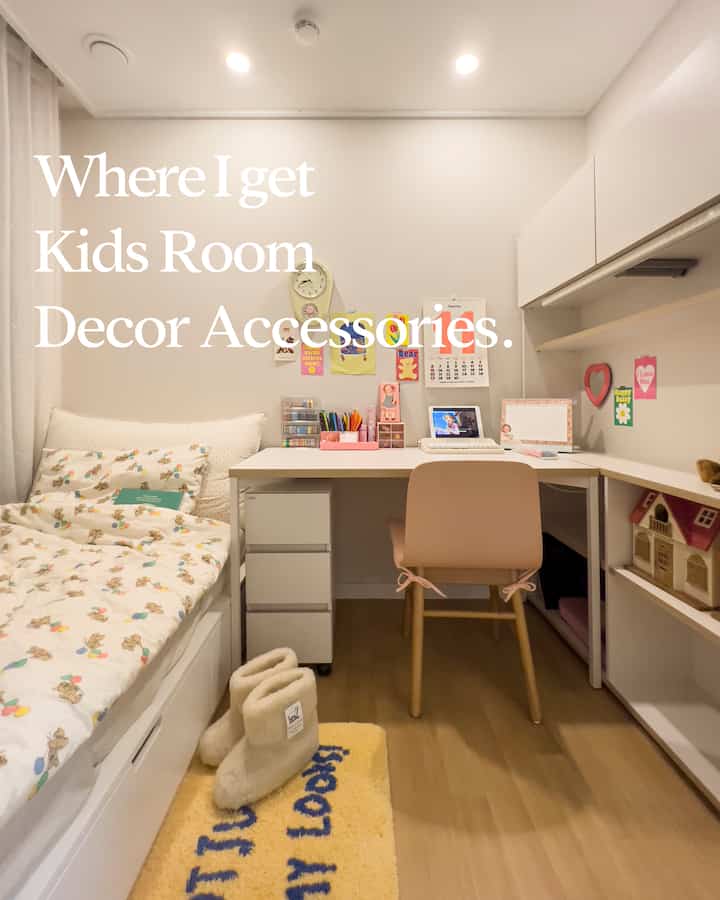 白と木目調の色調の子供部屋、かわいいデスクと壁飾りが配置されたコンパクトな学習空間