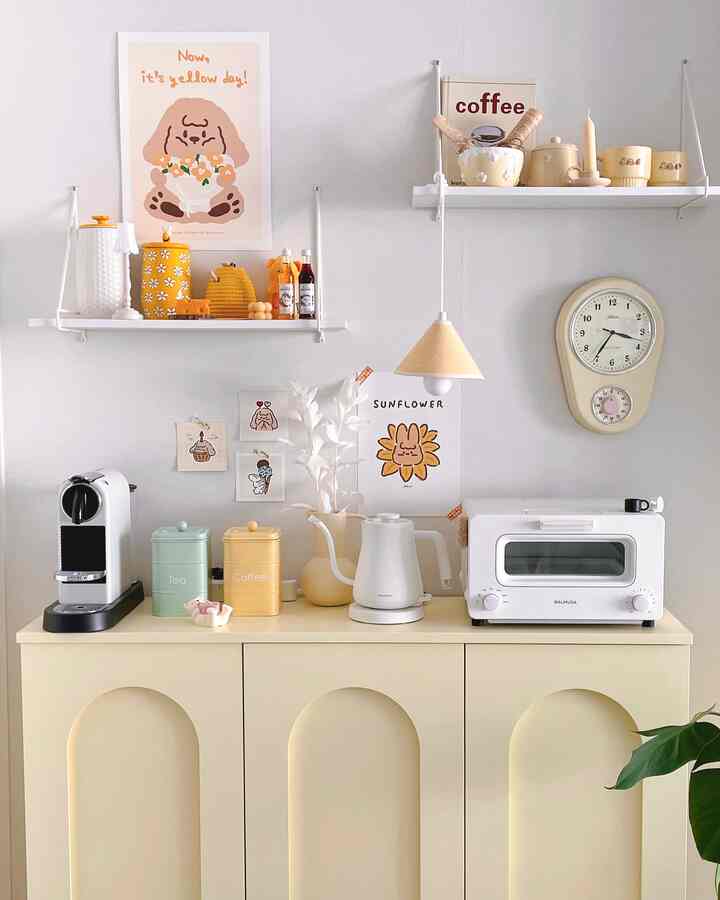 Bright white-toned kitchen space featuring a yellow cabinet, coffee machine, and toaster creating a cozy home cafe vibe