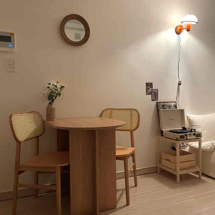 ホワイトとウッドトーンが調和したミニマルなダイニング空間、ラタンミラーと小物が温かみのあるおうちカフェ風のリビングインテリア