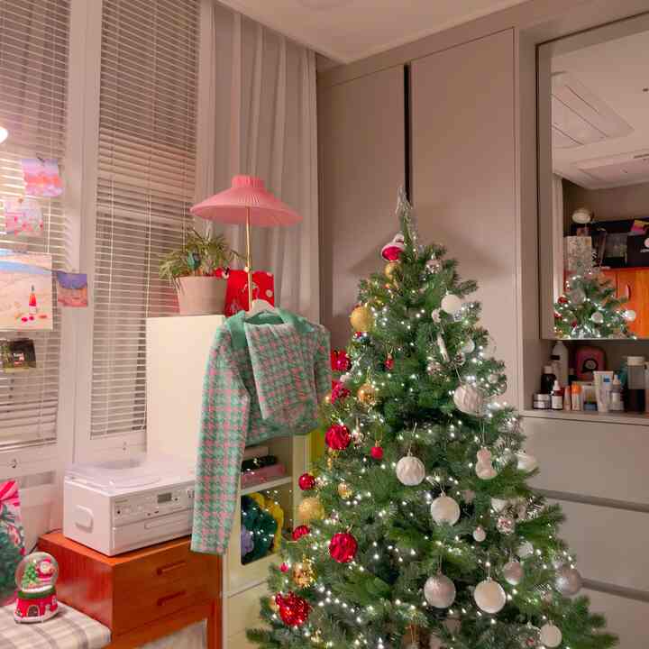 赤とゴールド、ホワイトとシルバーのオーナメントが飾られたクリスマスツリーがあるナチュラルな雰囲気のリビング